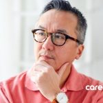 mature man with glasses thinking